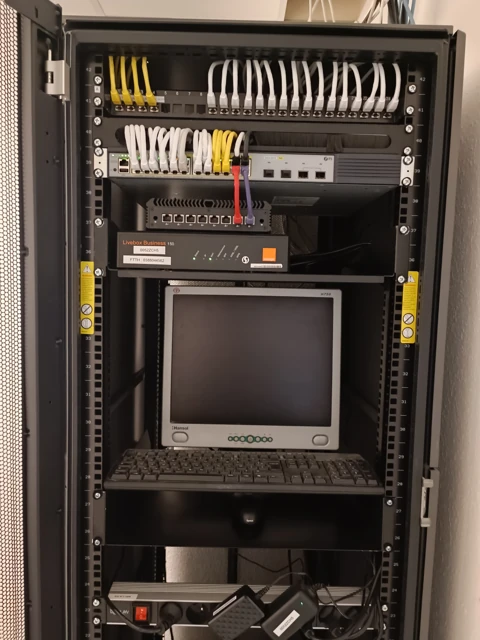 Brassage, écran et équipements regroupés dans une armoire ouverte.