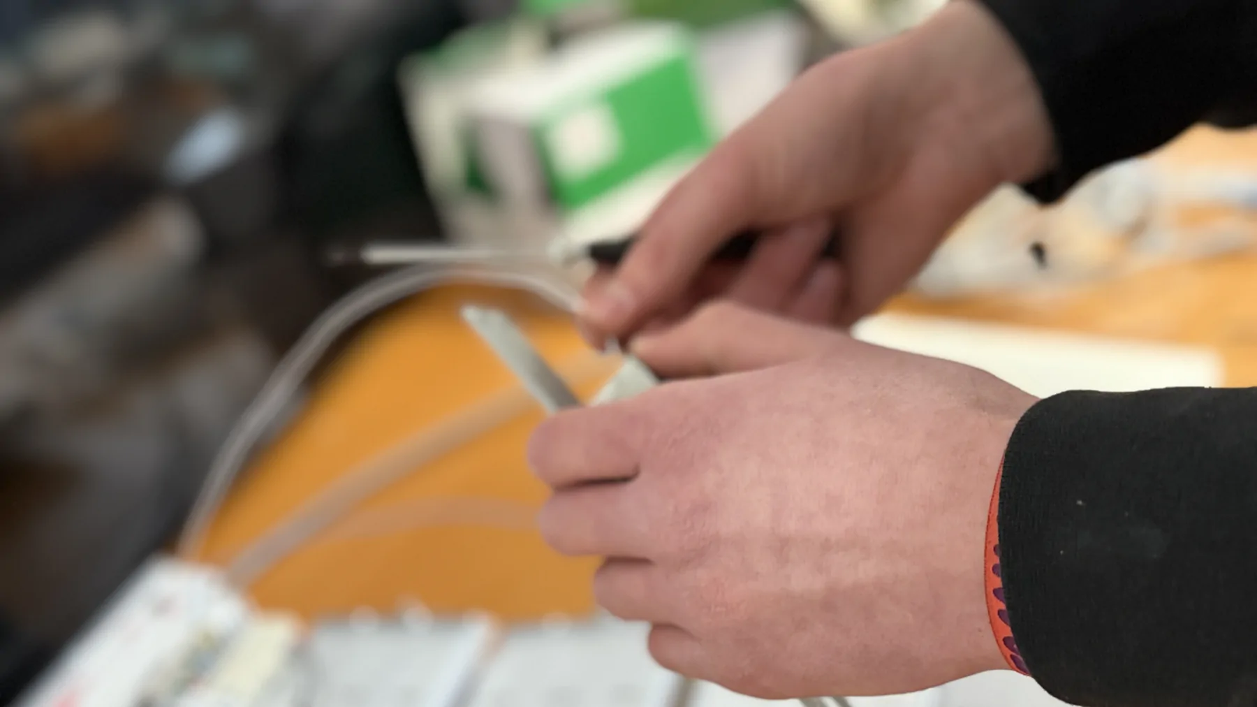 Mains préparant les conducteurs d’un équipement d’interphonie.