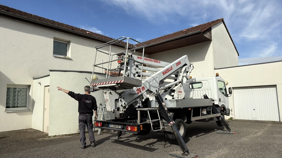 Vorbereiten des Zugangs zu einer Gebäudefassade mit einer fahrzeugmontierten Zugangsplattform und Alltech Techniker am Boden.