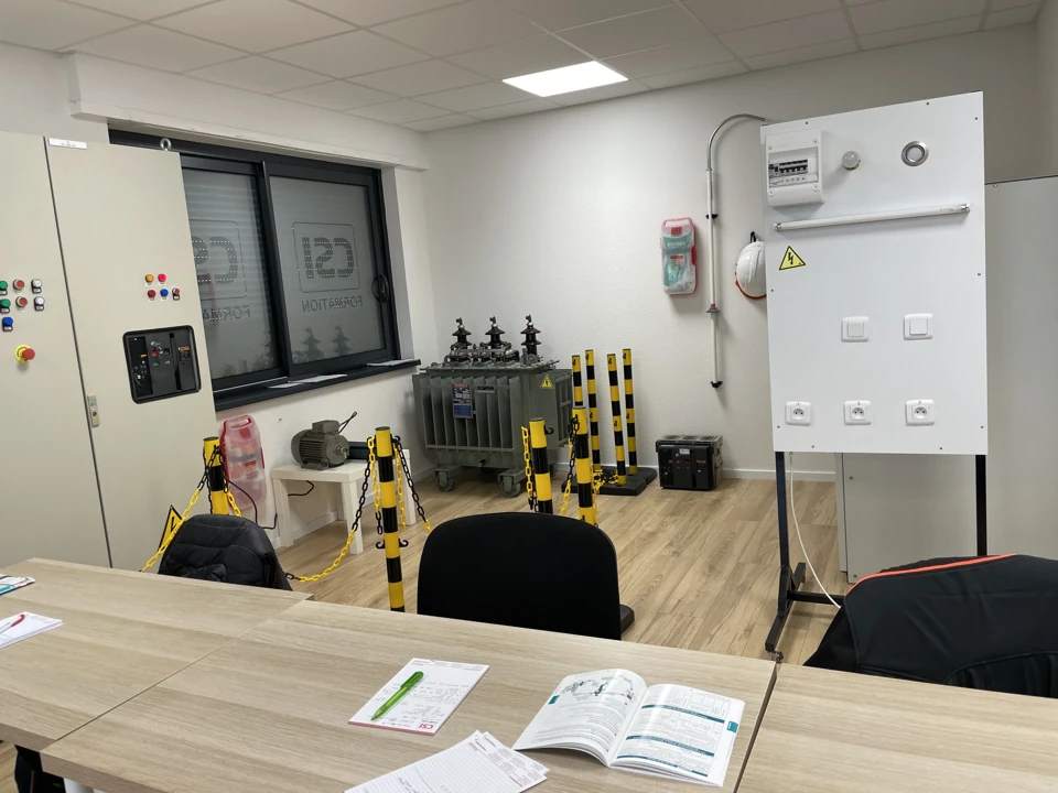 Elektrotrainingswerkstatt mit Demonstrationsausrüstung, Schutzausrüstung und Barrieren.