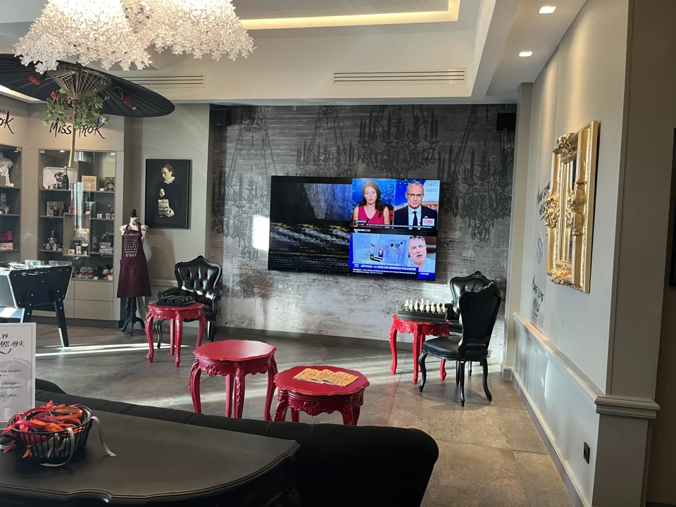 Hotel Arok — Lounge mit eingeschaltetem Wandfernseher.